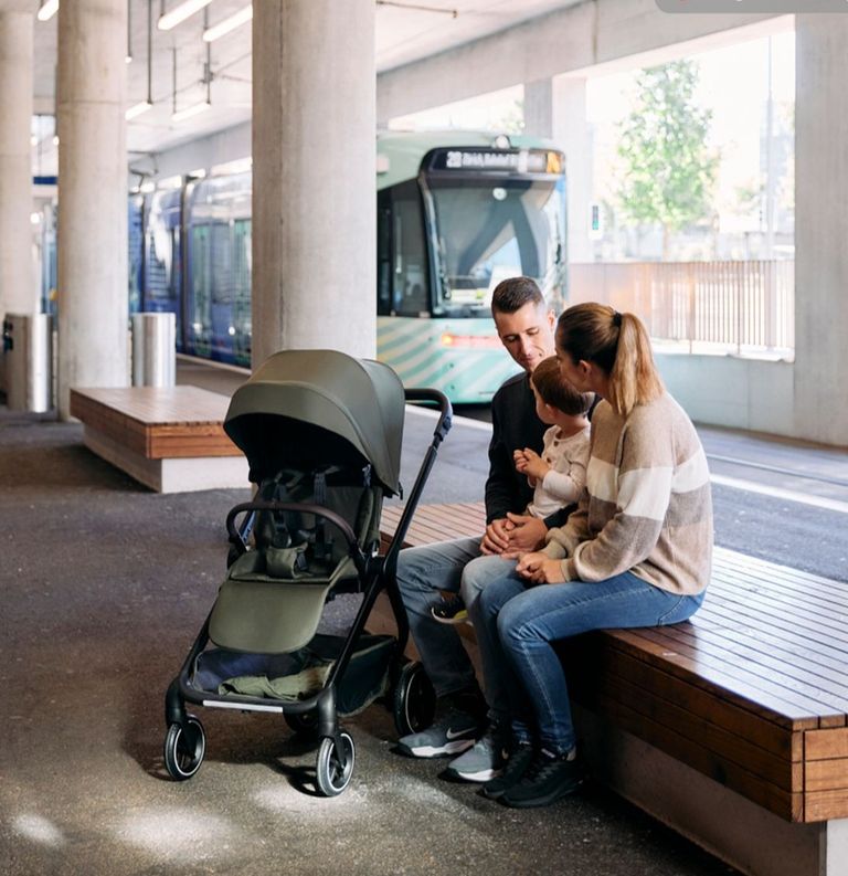eltern unterwegs in stadt mit abc design buggy city life warten mit kleinkind auf bank auf tram