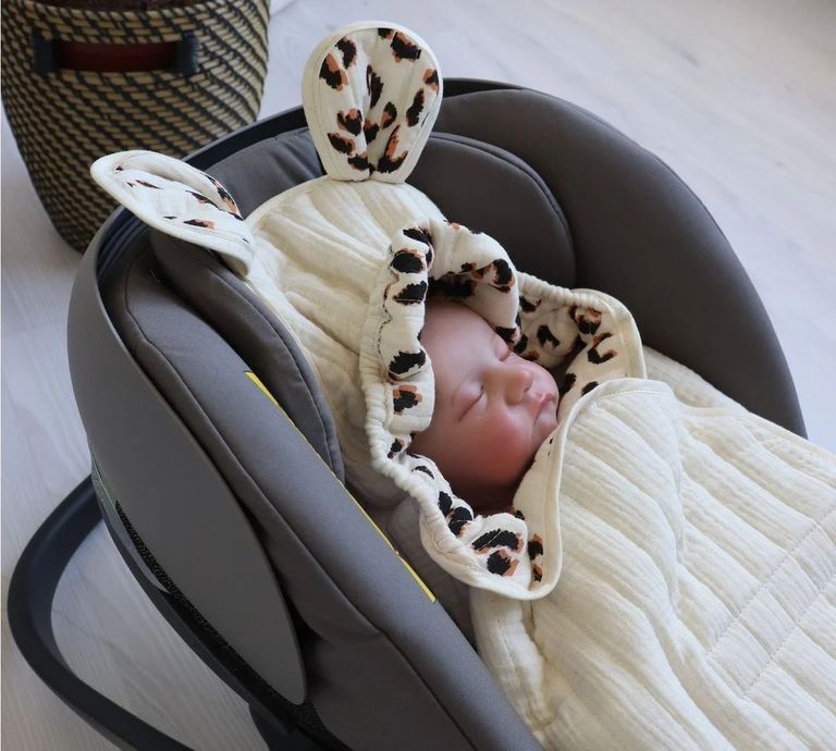 schlafendes baby in babyschale mit kaiser muselin einschlagdecke mouse sand stripes