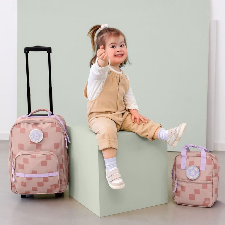 fröhliches mädchen mit rucksack kindertrolley lässig party rose