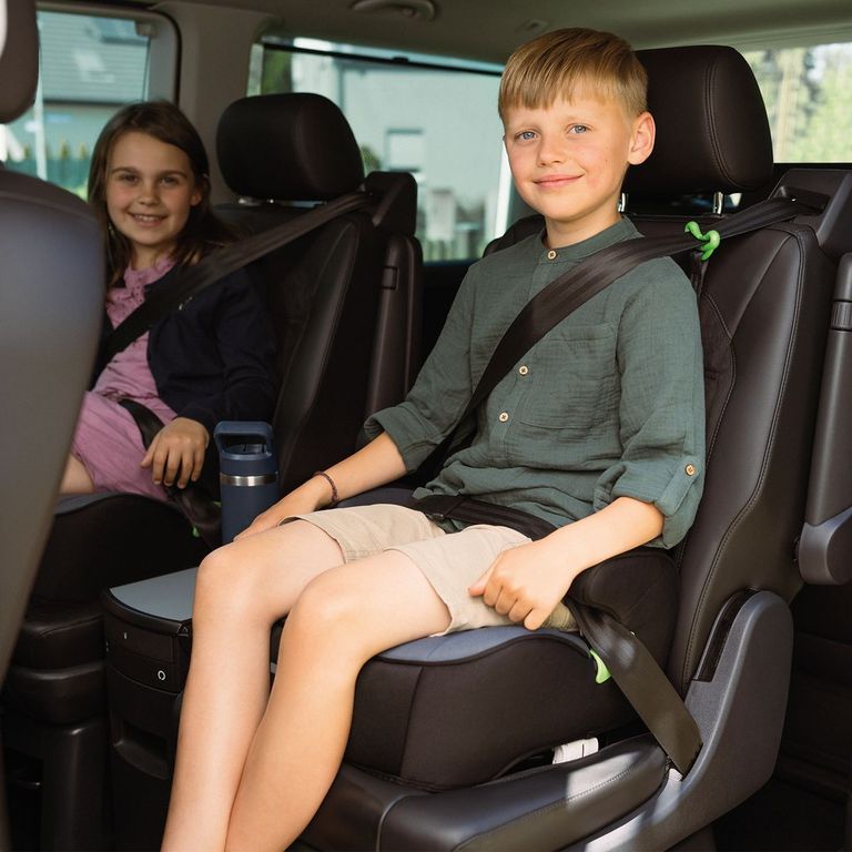 zwei fröhliche kinder im auto sitzen auf sitzerhöhung kindersitz