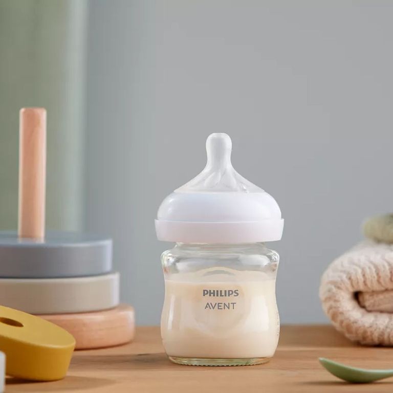 philips avent babyflasche weithals mit silikon trinksuager neben babyspielzeug