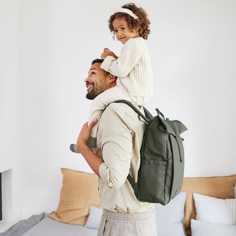 vater mit wickelrucksack lässig green label rolltop trägt tochter auf schultern