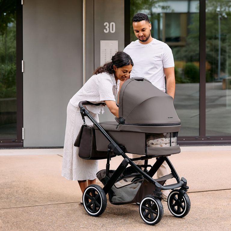 mutter vater vor hauseingang mit baby im abc design salsa 5 air kombi-kinderwagen pine