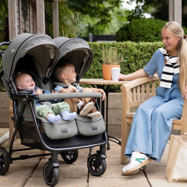 mutter im cafe mit baby kleinkind im joie geschwisterwagen