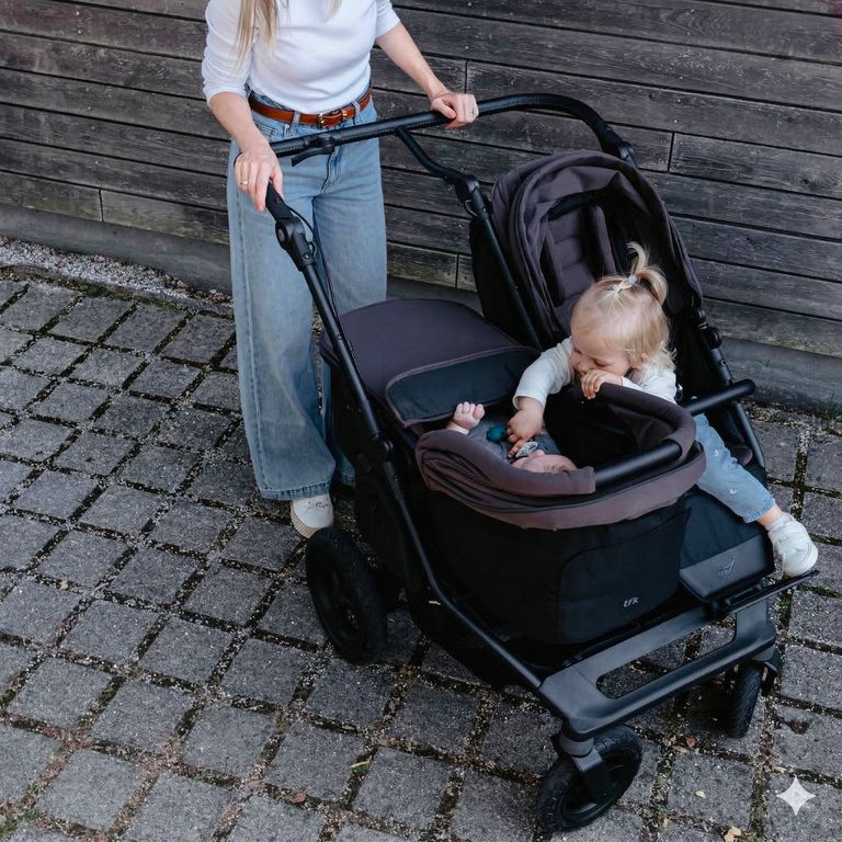 kleinkind spielt mit baby geschwisterkind im geschwisterwagen tfk duo