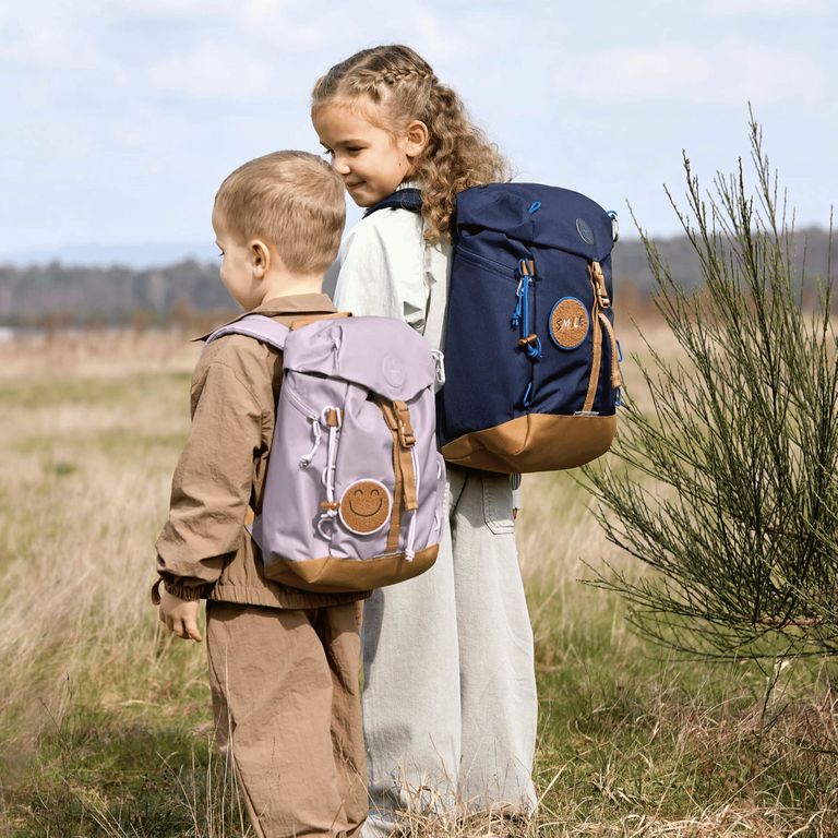 zwei kleinkinder mit kinderrrucksack im feld unterwegs ausflug