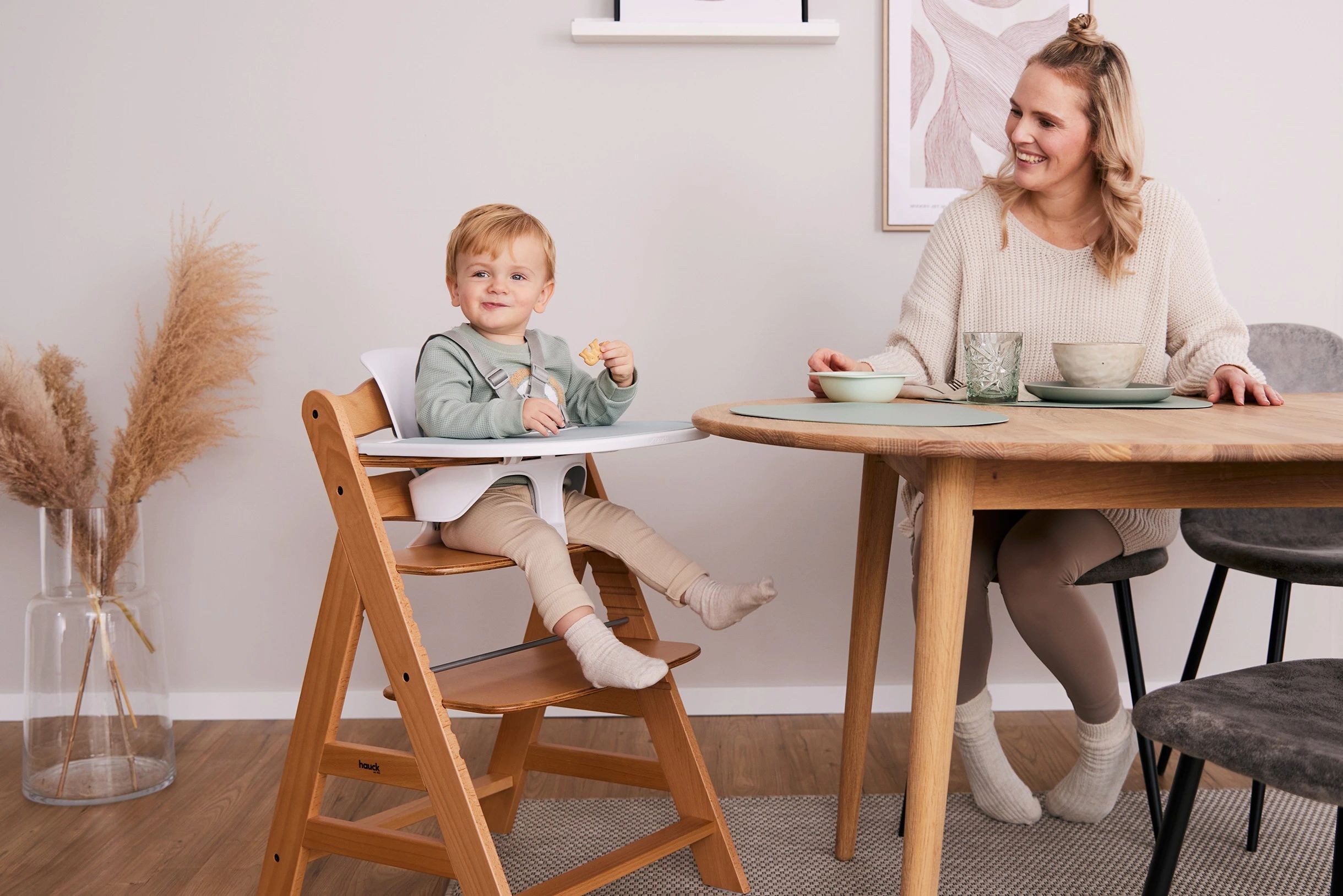Kind sitzt im hauck Holz-Treppenhochstuhl am Esstisch